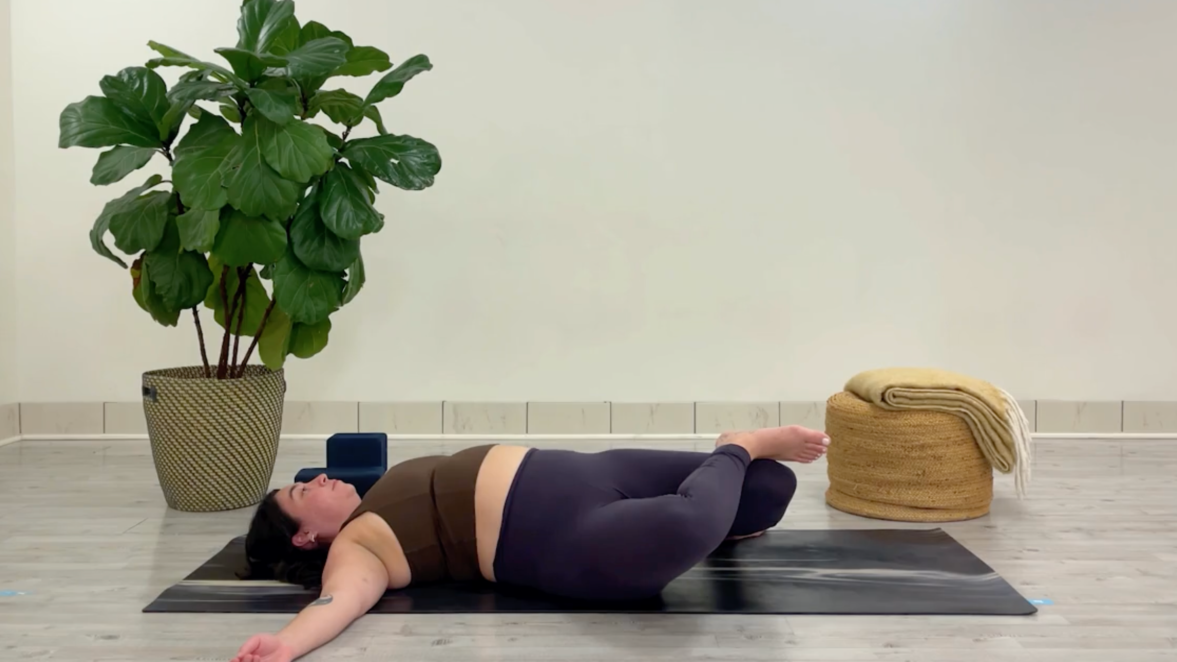 Yoga teacher Taylor Lorenz in Windshield Wipers, one of the best yoga poses for chilling out